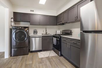 A kitchen with gray cabinets and stainless steel appliances